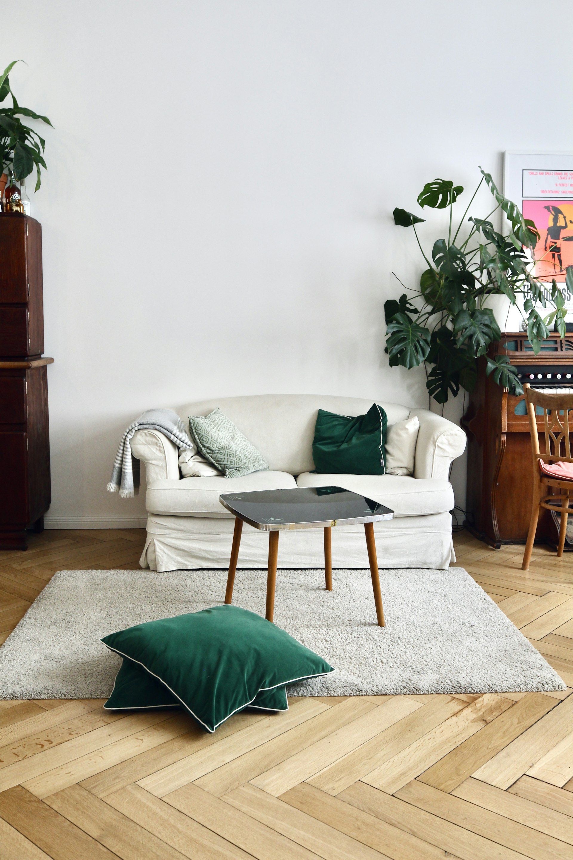 Cozy living room with herringbone hardwood floors and forest-green accents.
